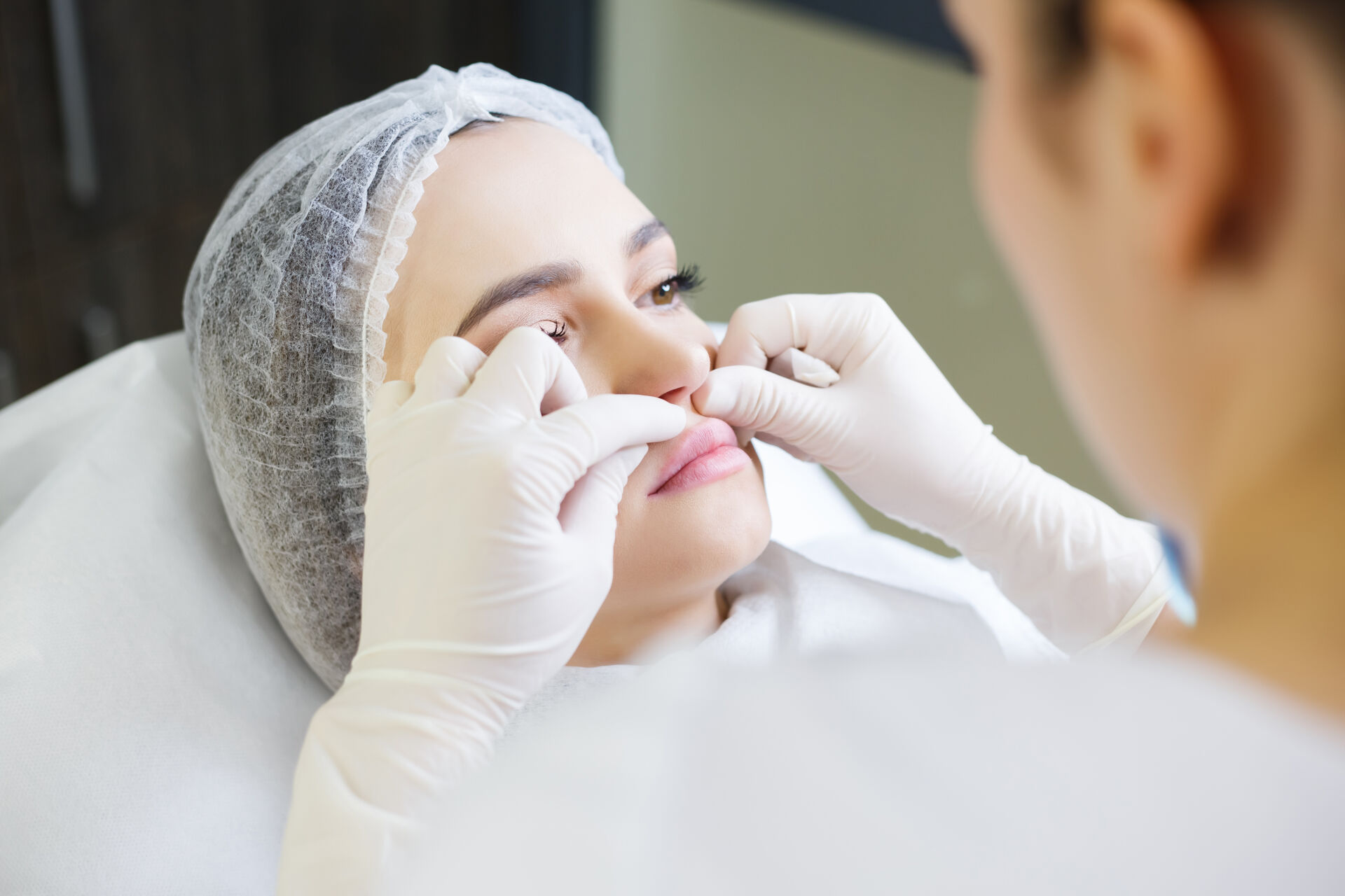 Doctor man with white medical gloves touches girl face.
