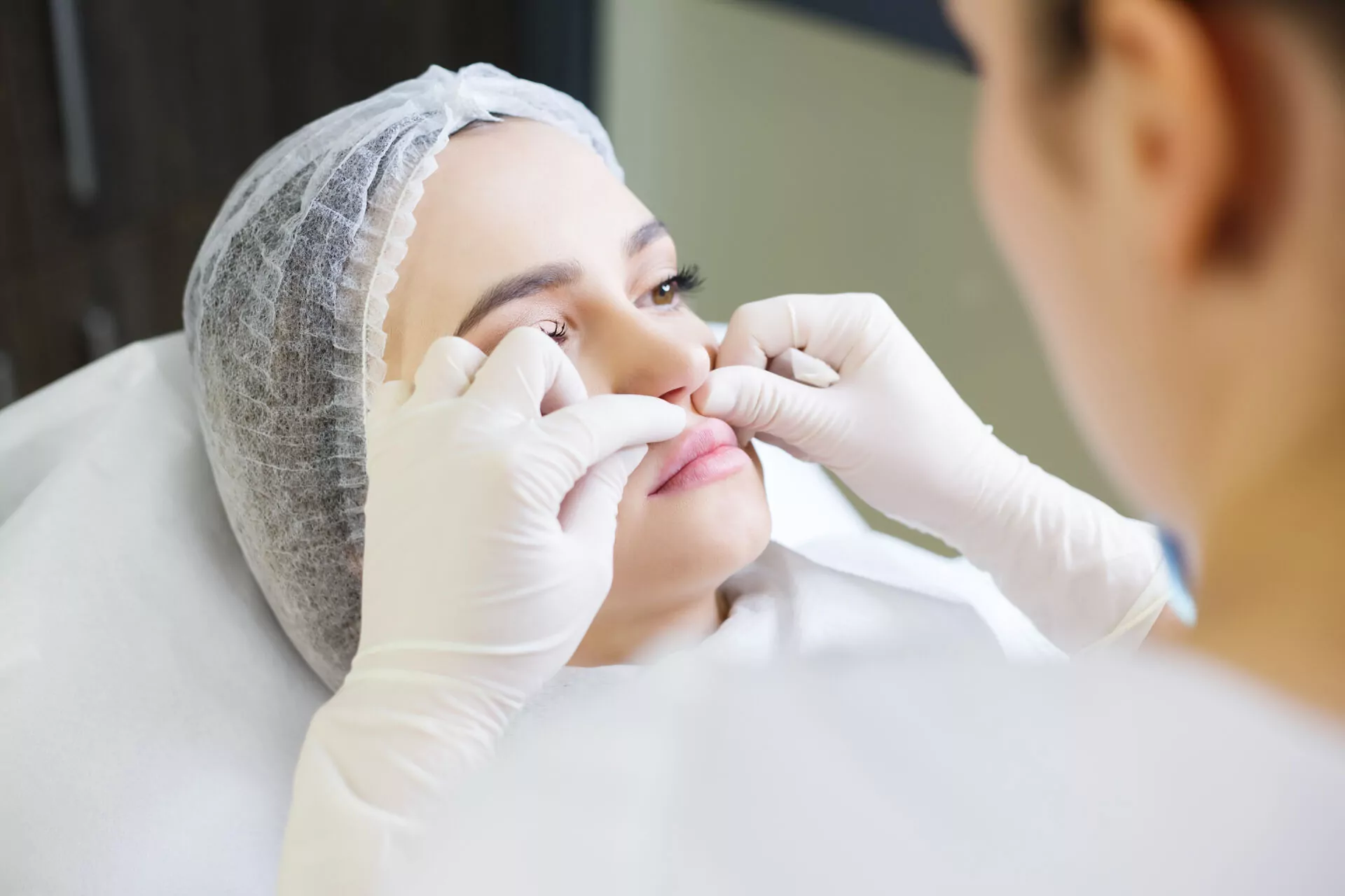 Ein Arzt mit weißen medizinischen Handschuhen berührt das Gesicht eines Mädchens. Ein Arzt mit weißen medizinischen Handschuhen berührt das Gesicht eines Mädchens.